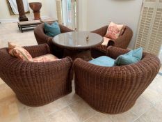 A group of four rattan chairs; and a rattan glass topped glass table