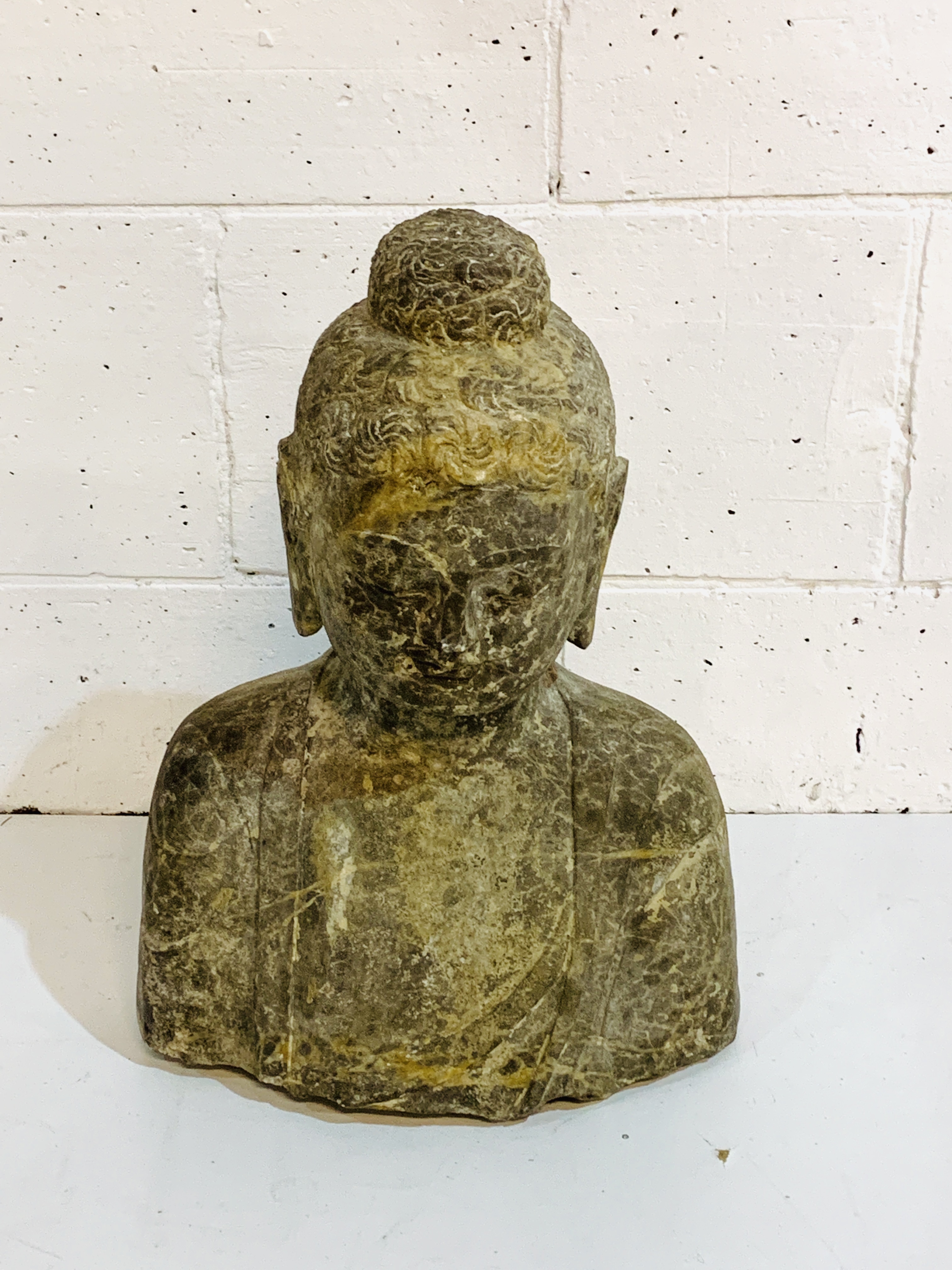 Carved stone bust of a Buddha