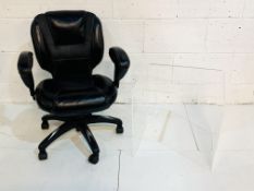 Black leather adjustable office chair together with a perspex display table