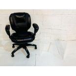 Black leather adjustable office chair together with a perspex display table