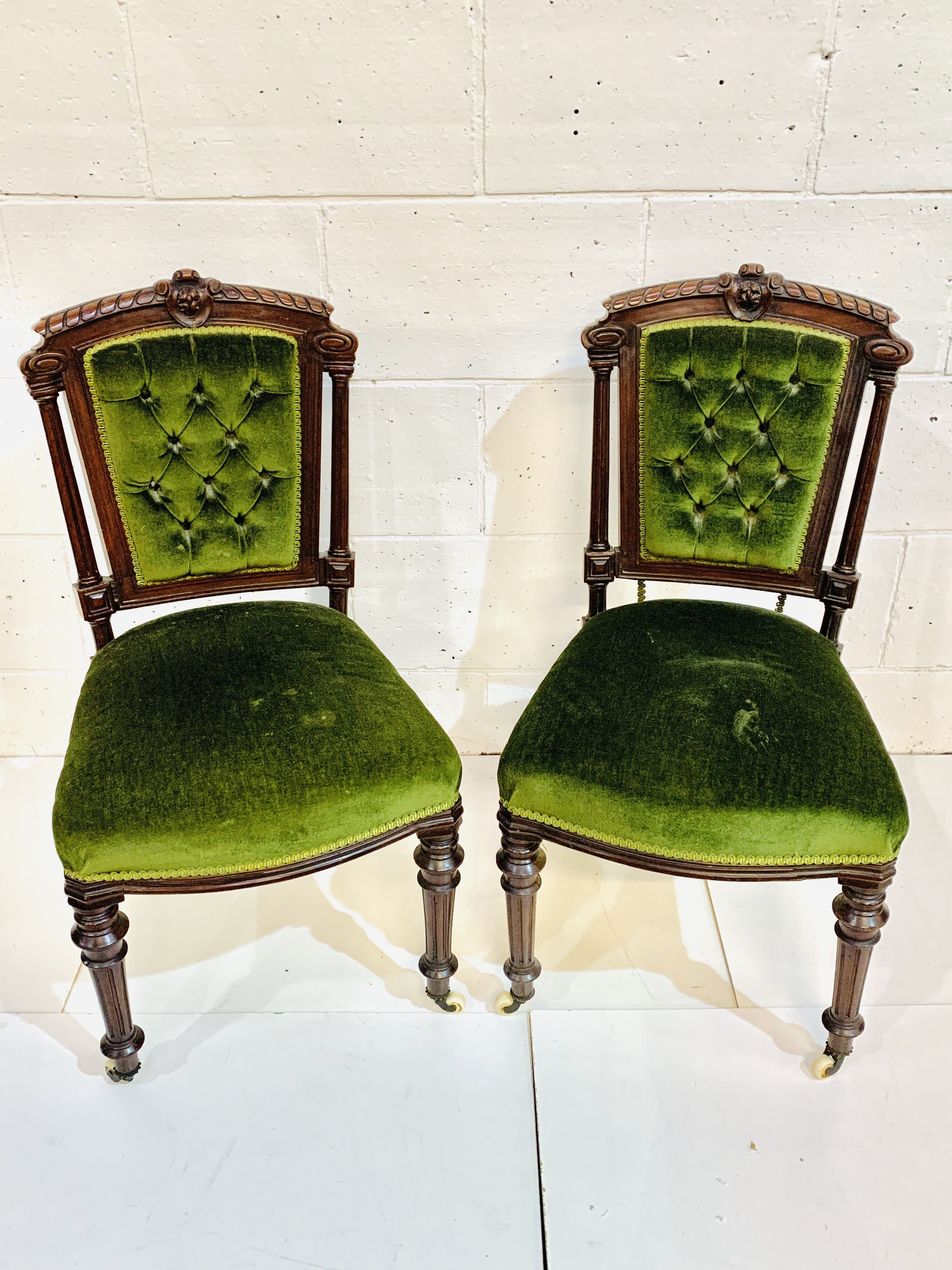 A pair of mahogany framed column sided button back dining chairs.