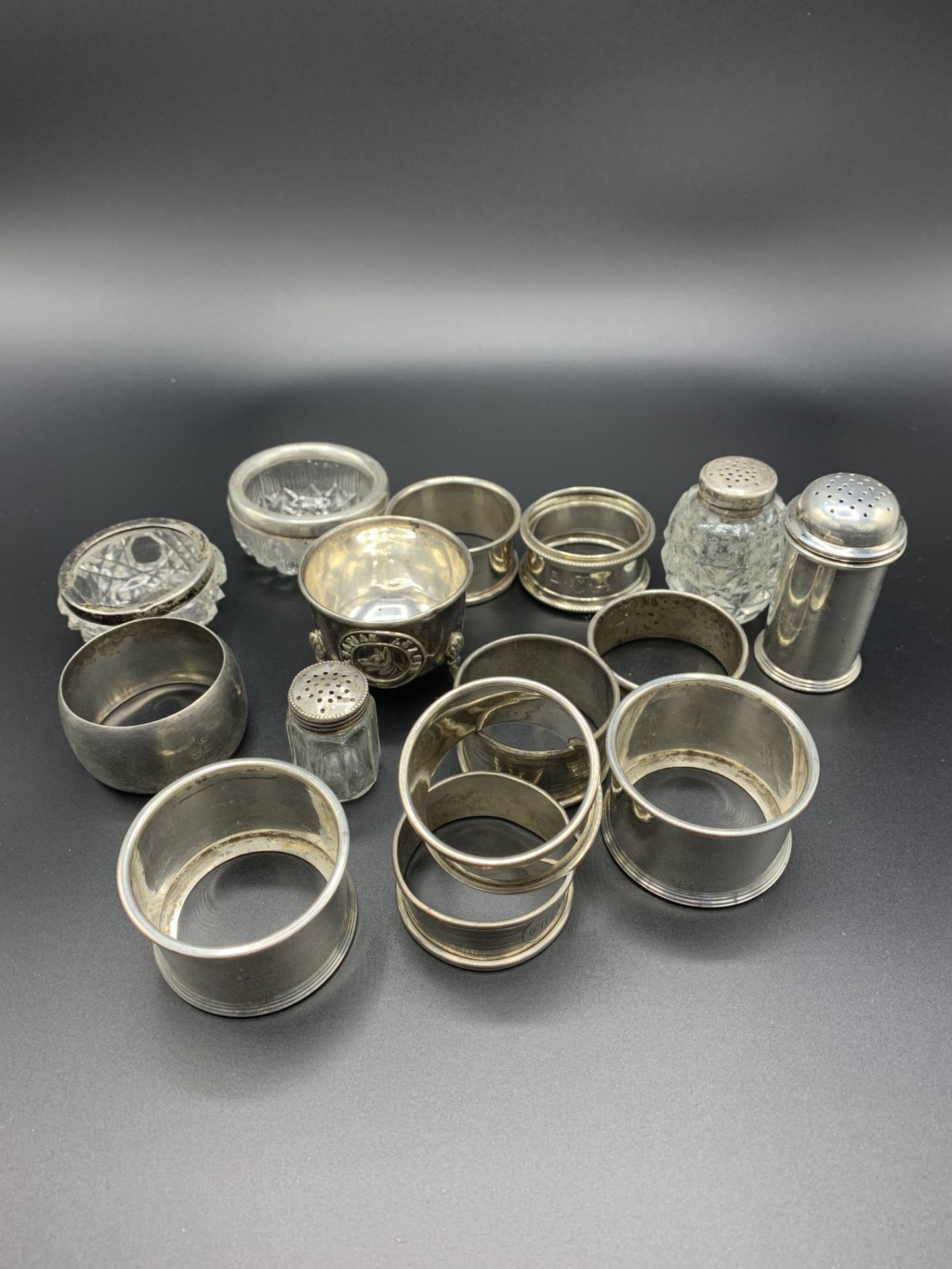 A collection of different sterling silver napkin rings and condiments