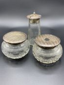 Two cut glass trinket pots with silver lids, and a cut glass tapered sugar caster with silver lid