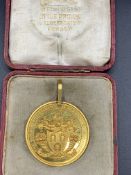 Gold coloured medal with coat of arms and inscribed "The Worshipful Company of Farriers of London"