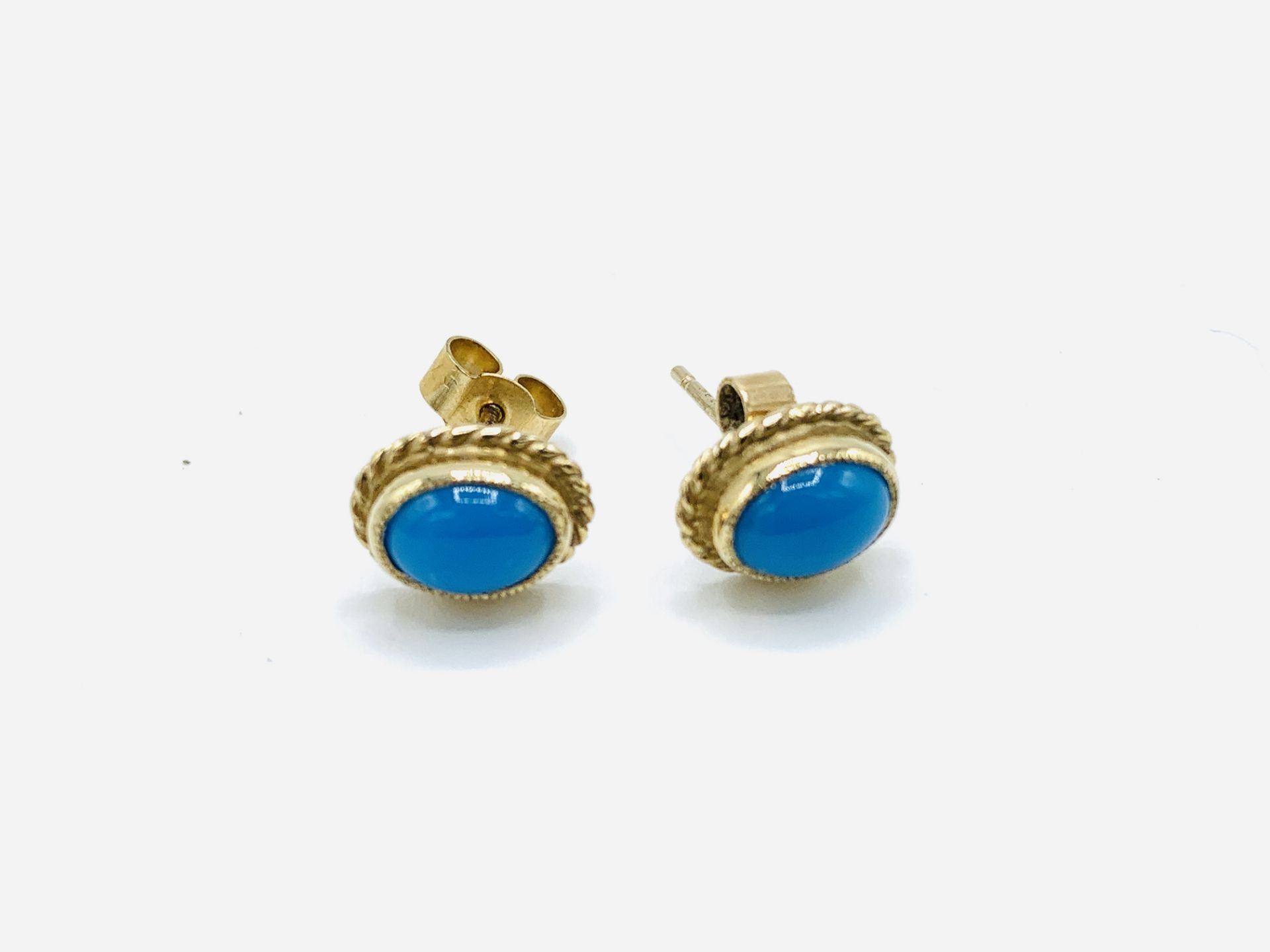 Gold coloured earrings with turquoise centre stone. Estimate £10-20.