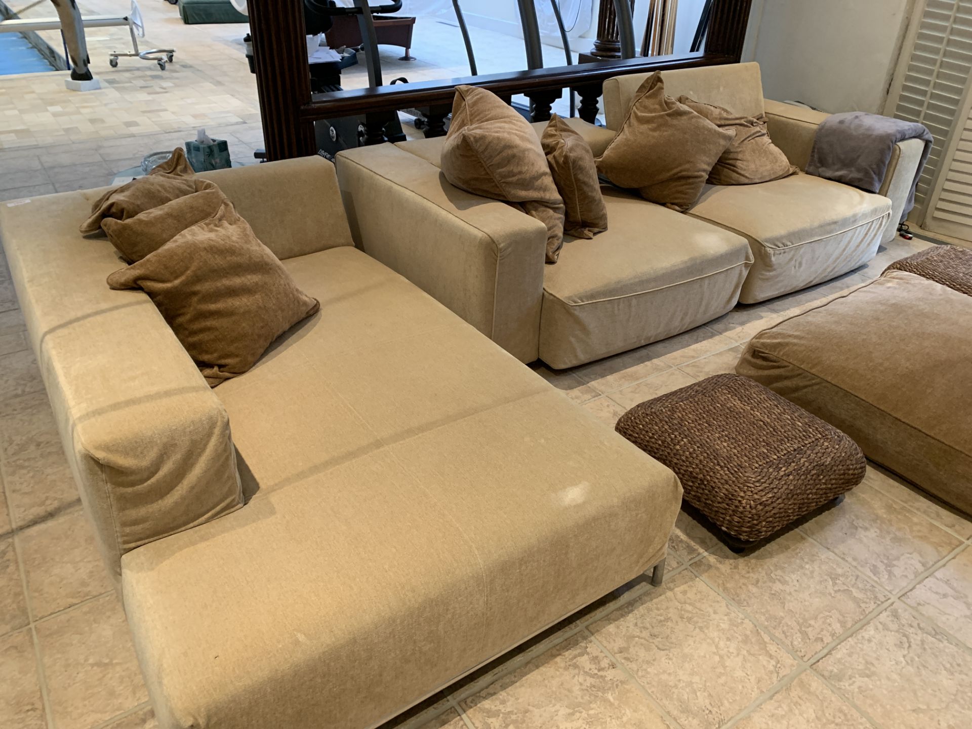 Light brown sofa, a light brown day bed, light brown floor cushion and a rattan stool