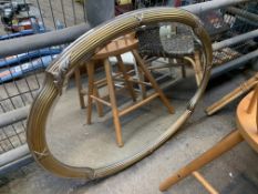 Gilt shaped oval bevelled edge wall mirror.