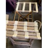 Four wooden and webbing suitcase stands, together with another.