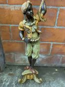 Figural carved wood lamp standard in the form of a boy in Middle Eastern clothing.