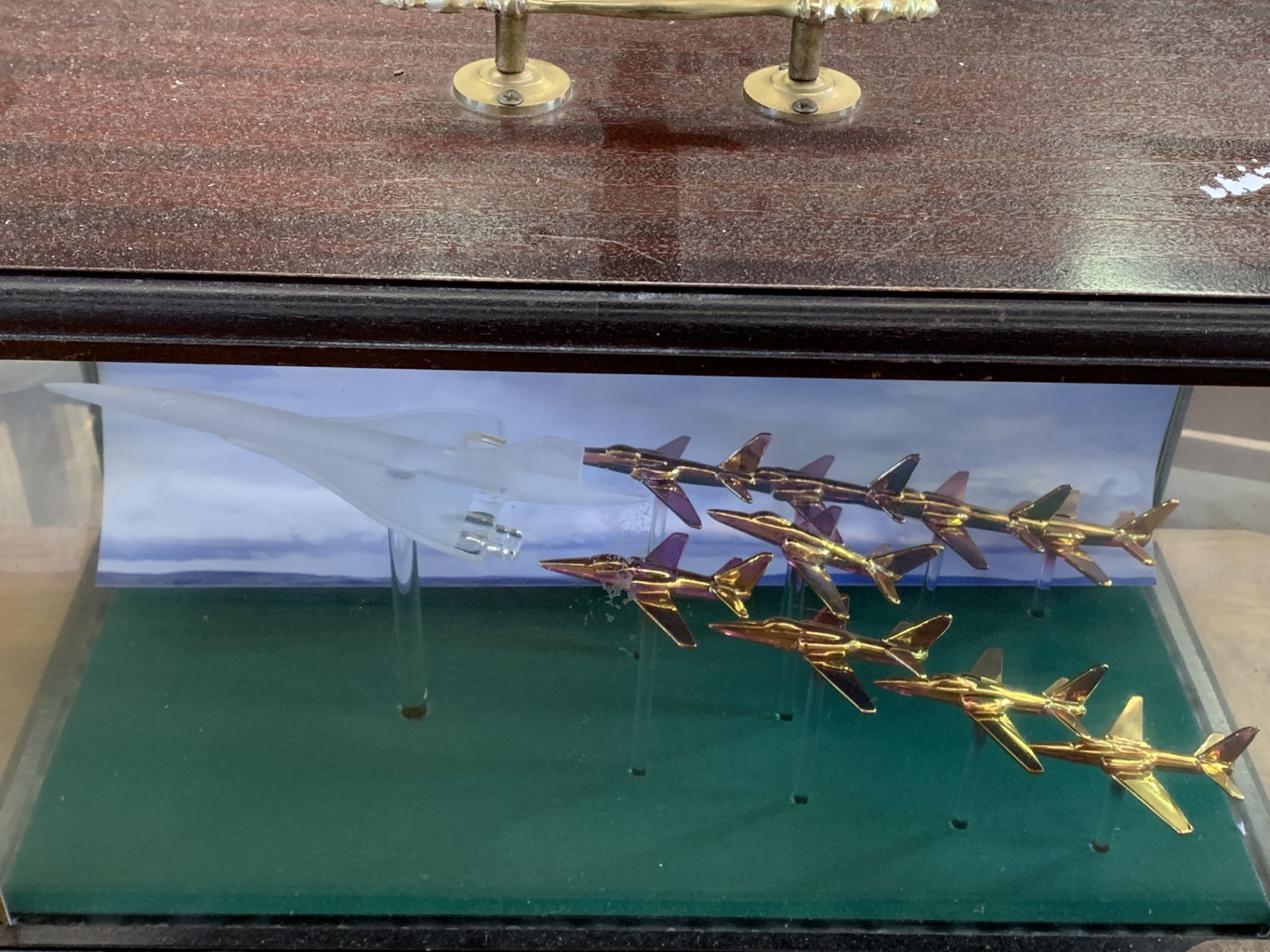 Mahogany display case containing a brass and crystal model of a Concorde and Red Arrows fly past.