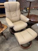 Light brown leather swivel armchair and matching footstool, by Ekornes