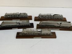 Five diecast model locomotives on wooden bases.