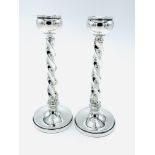 A pair of silver candlesticks with barley twist stems