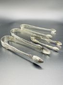 Four silver sugar tongs