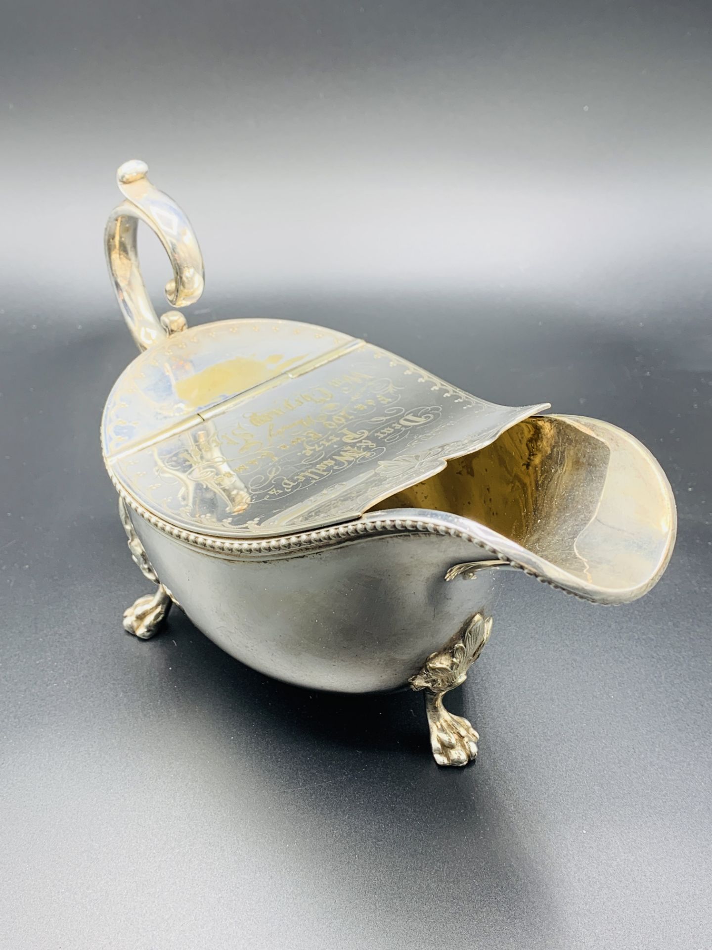 A large silver plate sauce boat