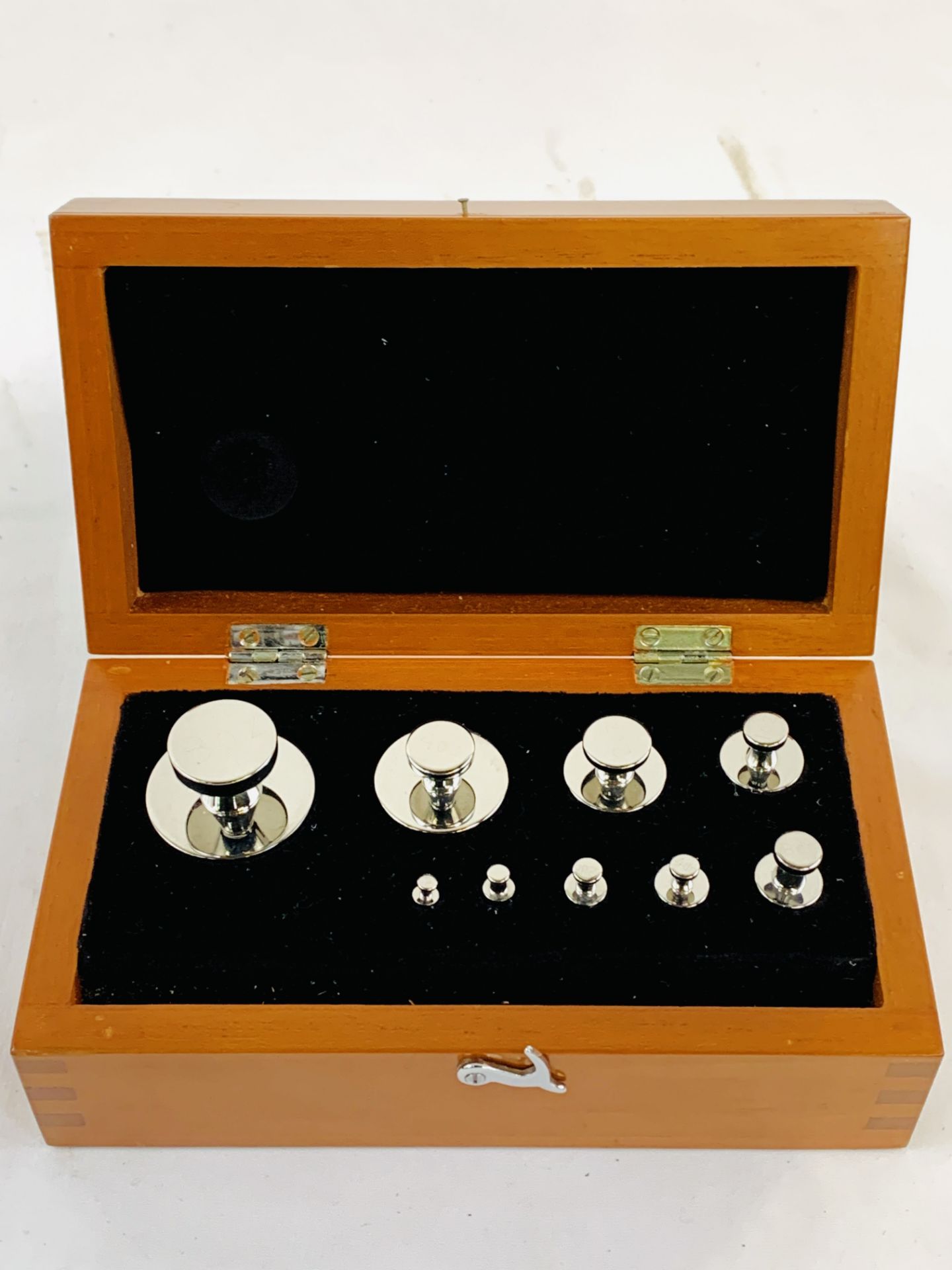 A boxed set of polished metal weights, from 1/2 dram to 8oz