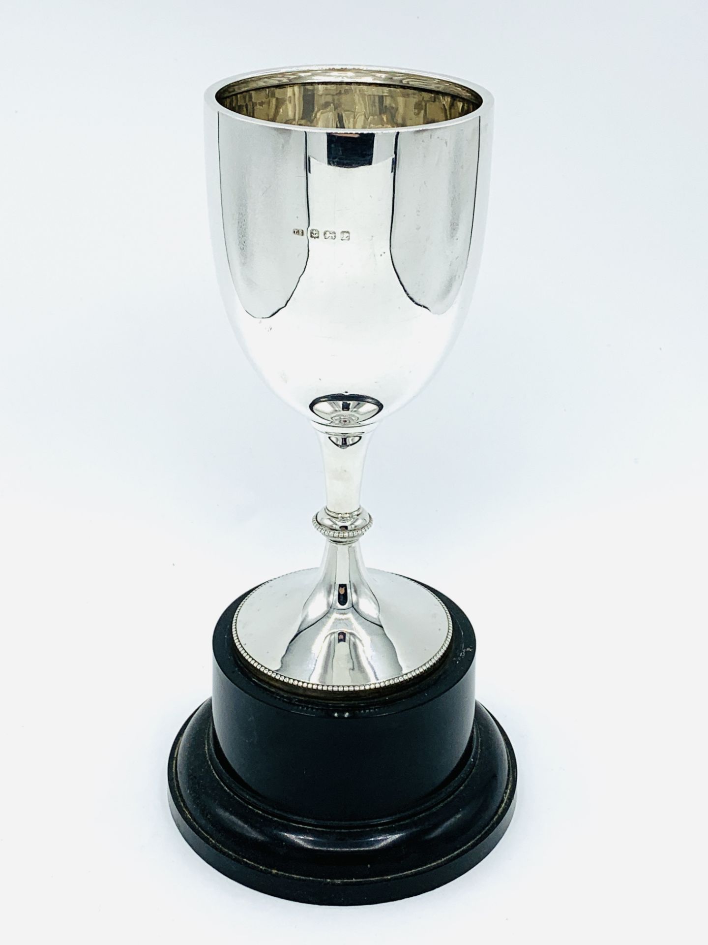 Silver goblet on black trophy stand