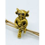 15ct gold pin mounted with a seated horned figure with diamond chip eyes