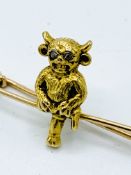 15ct gold pin mounted with a seated horned figure with diamond chip eyes