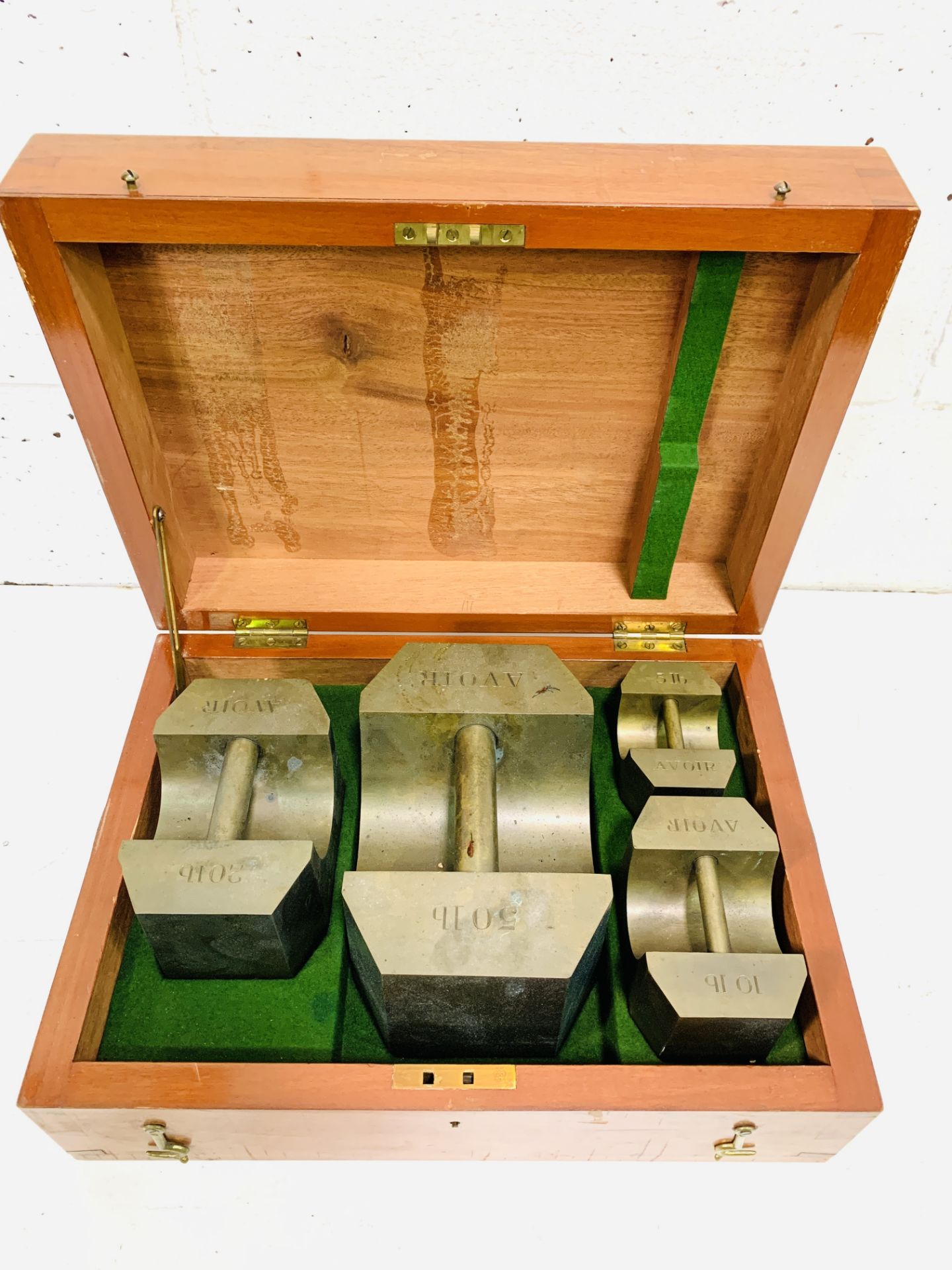 A boxed set of Avoir brass standard weights: 50lbs, 20lbs, 10lbs and 5lbs by De Grave, London.