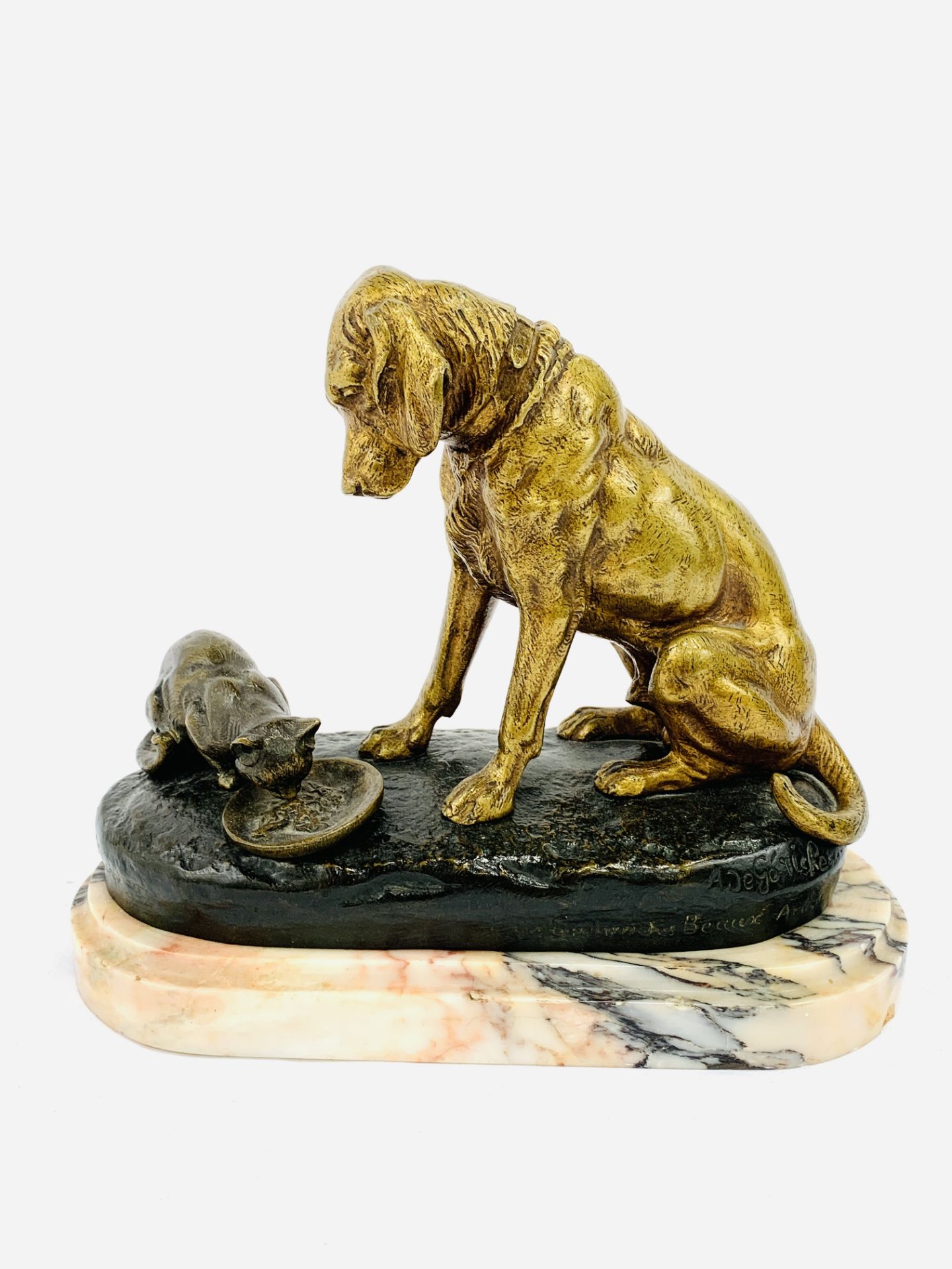 Brass/bronze figure of a dog sitting over a cat eating from a dish, signed A de Gericke