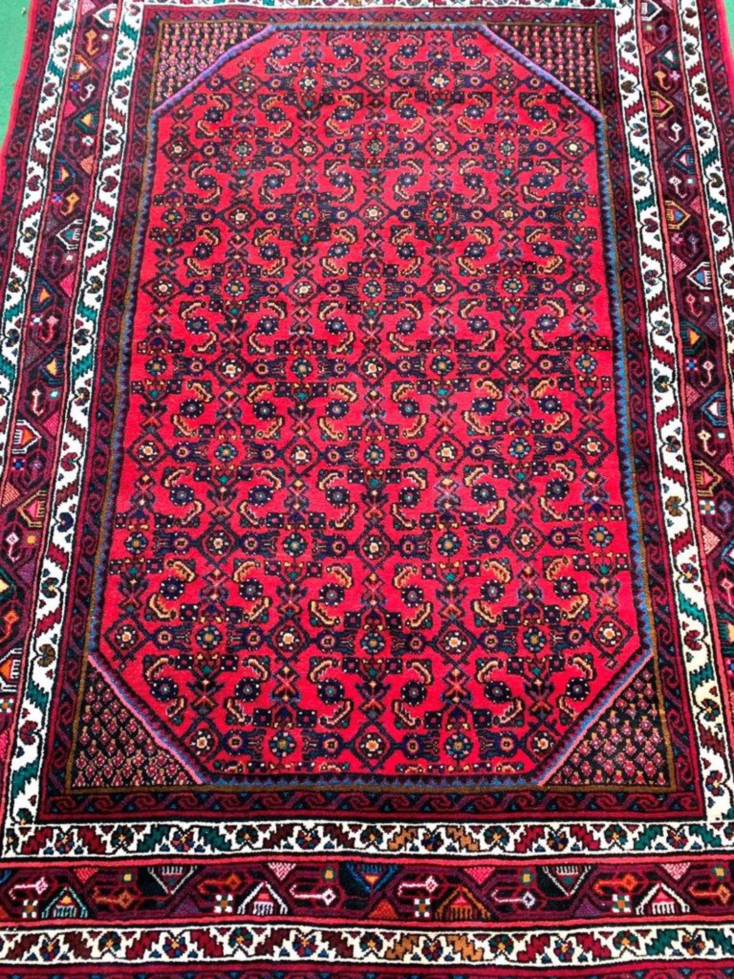 Dark red ground hand knotted wool rug