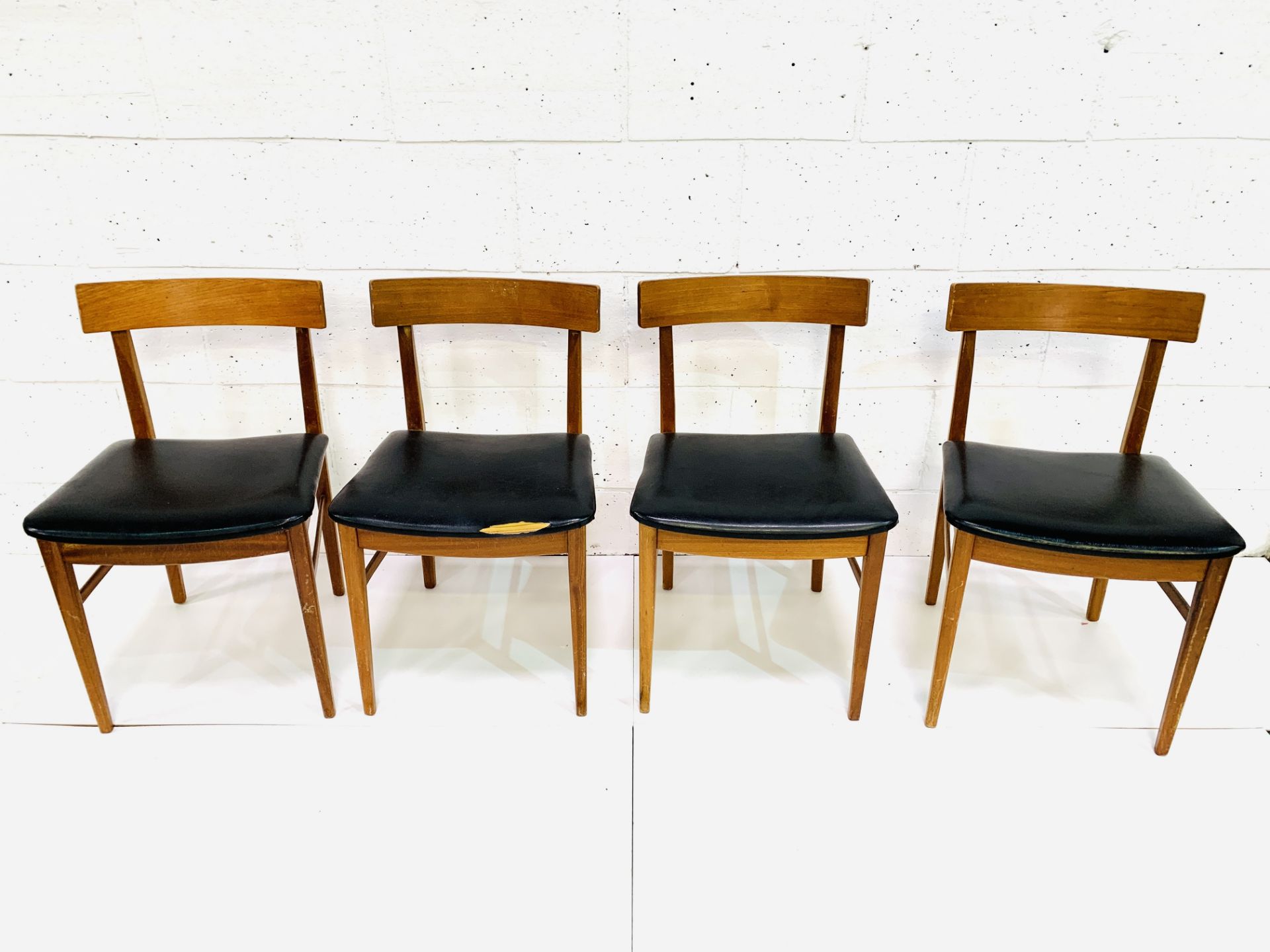 Four teak framed curved back dining chairs