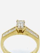 750 gold ring with baguette cut centre diamond and diamonds to shoulders