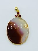 Banded Agate and ruby pendant on yellow metal.