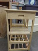 Two pine kitchen trolleys on casters.