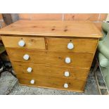 Pine chest of two over three drawers with white ceramic handles