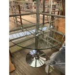 Circular glass top table with four clear plastic and chrome framed chairs