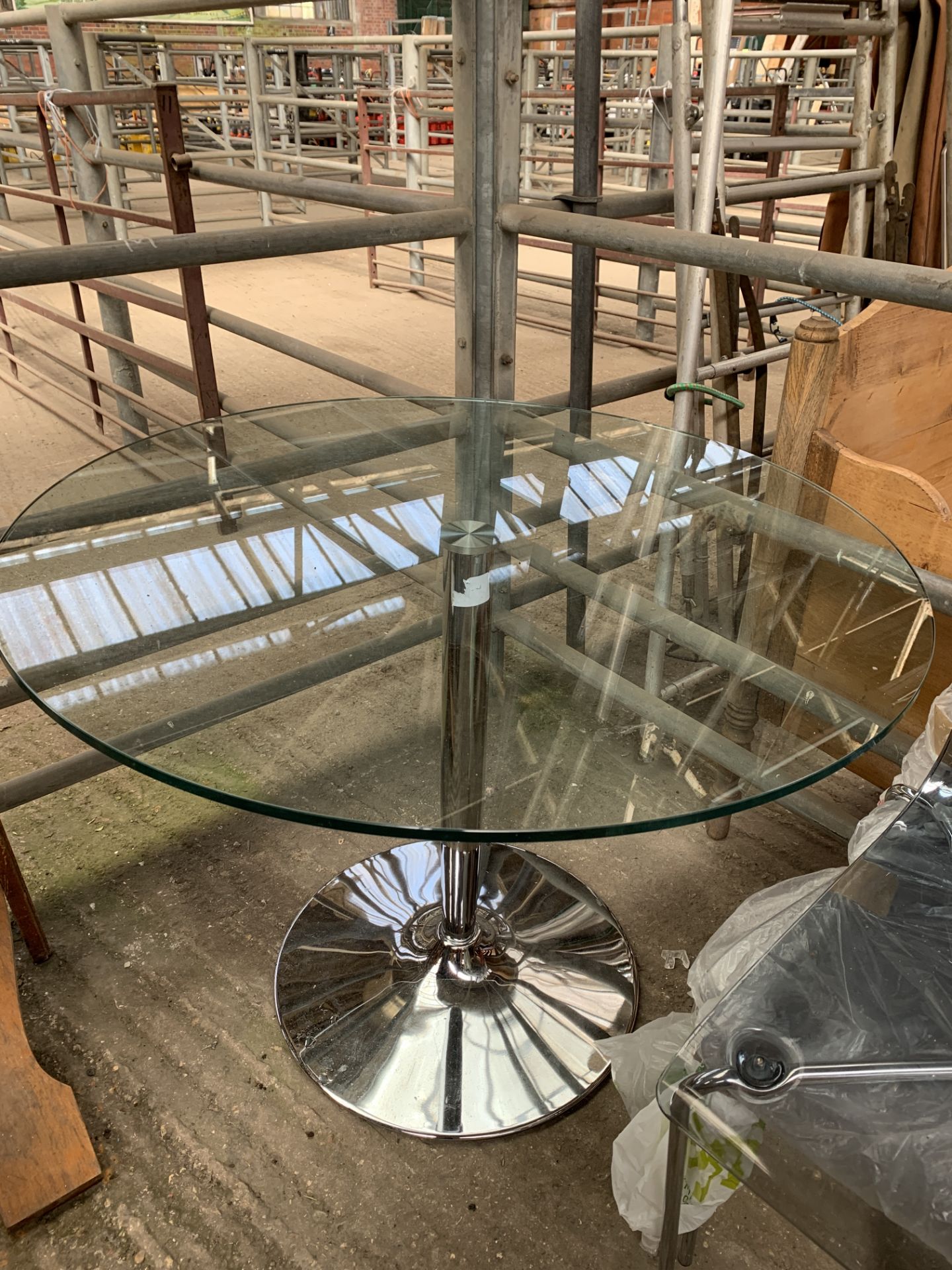 Circular glass top table with four clear plastic and chrome framed chairs