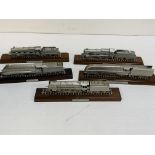 Five diecast model locomotives on wooden bases.