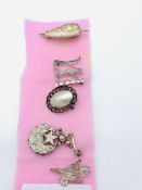 Six various silver coloured brooches