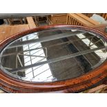 Wood frame oval bevelled edge wall mirror and an unframed circular wall mirror