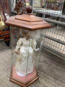 Porcelain head doll in hexagonal display case, and a carved giraffe