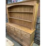 Pine dresser with two shelves above four frieze drawers over four cupboards