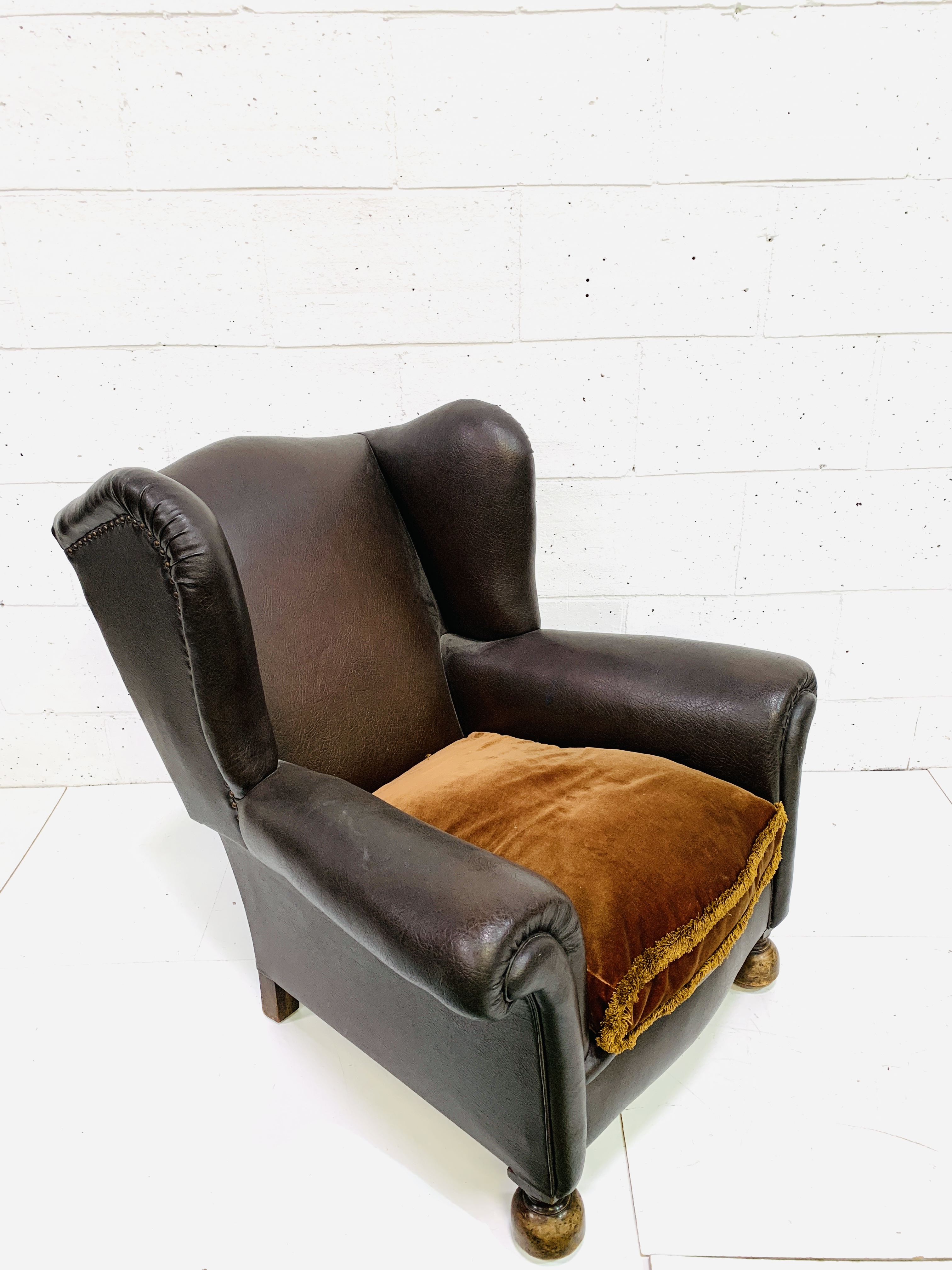 Dark brown leather deep wing back armchair