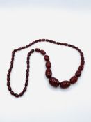 A necklace of graduated cherry amber bakelite beads