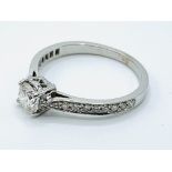 White gold solitaire ring with diamond shoulders