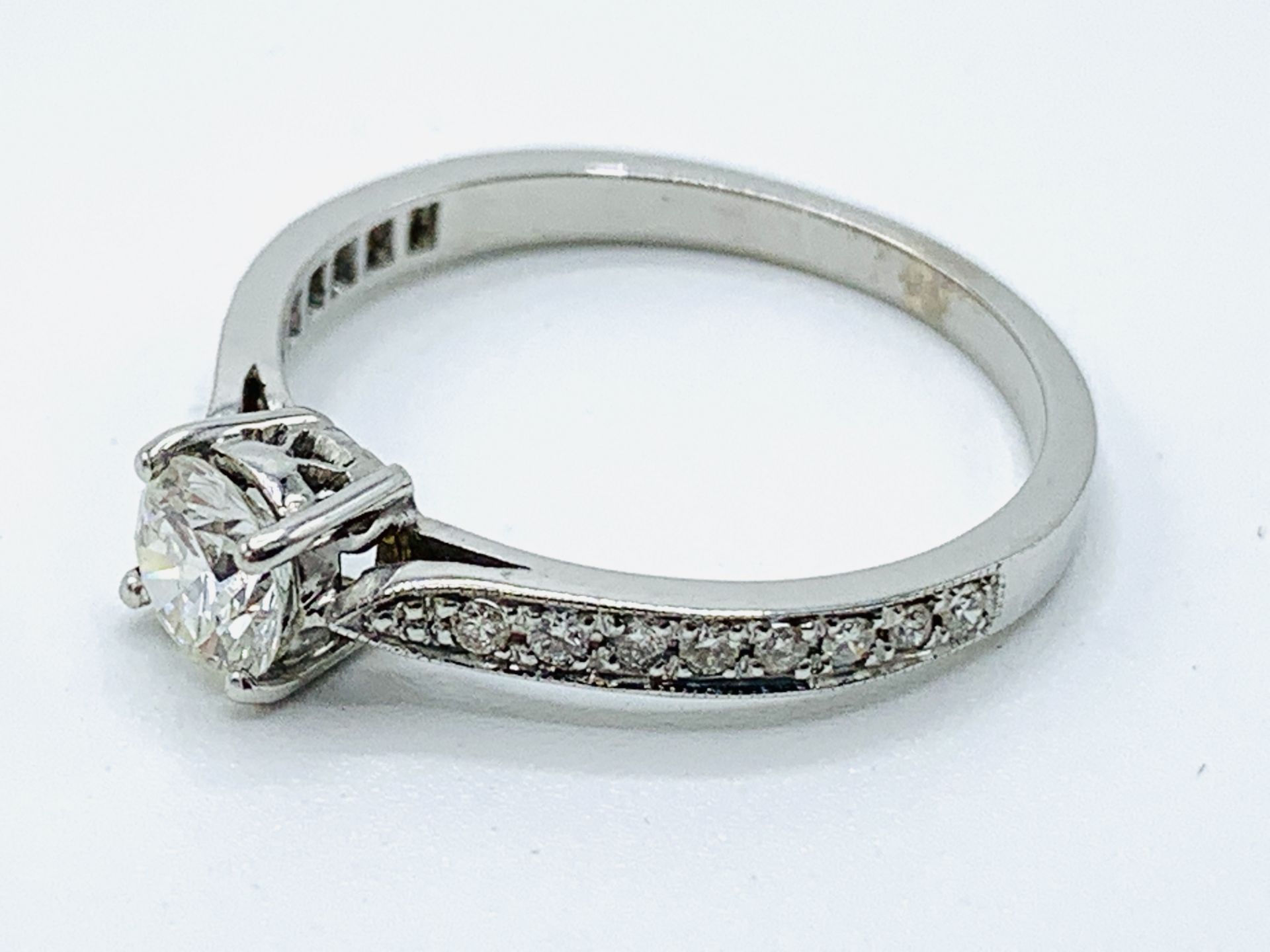 White gold solitaire ring with diamond shoulders