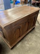 Oak coffer with three carved panels, metal carry handles, bun feet to front