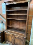 Oak open bookcase with four shelves above double cupboard