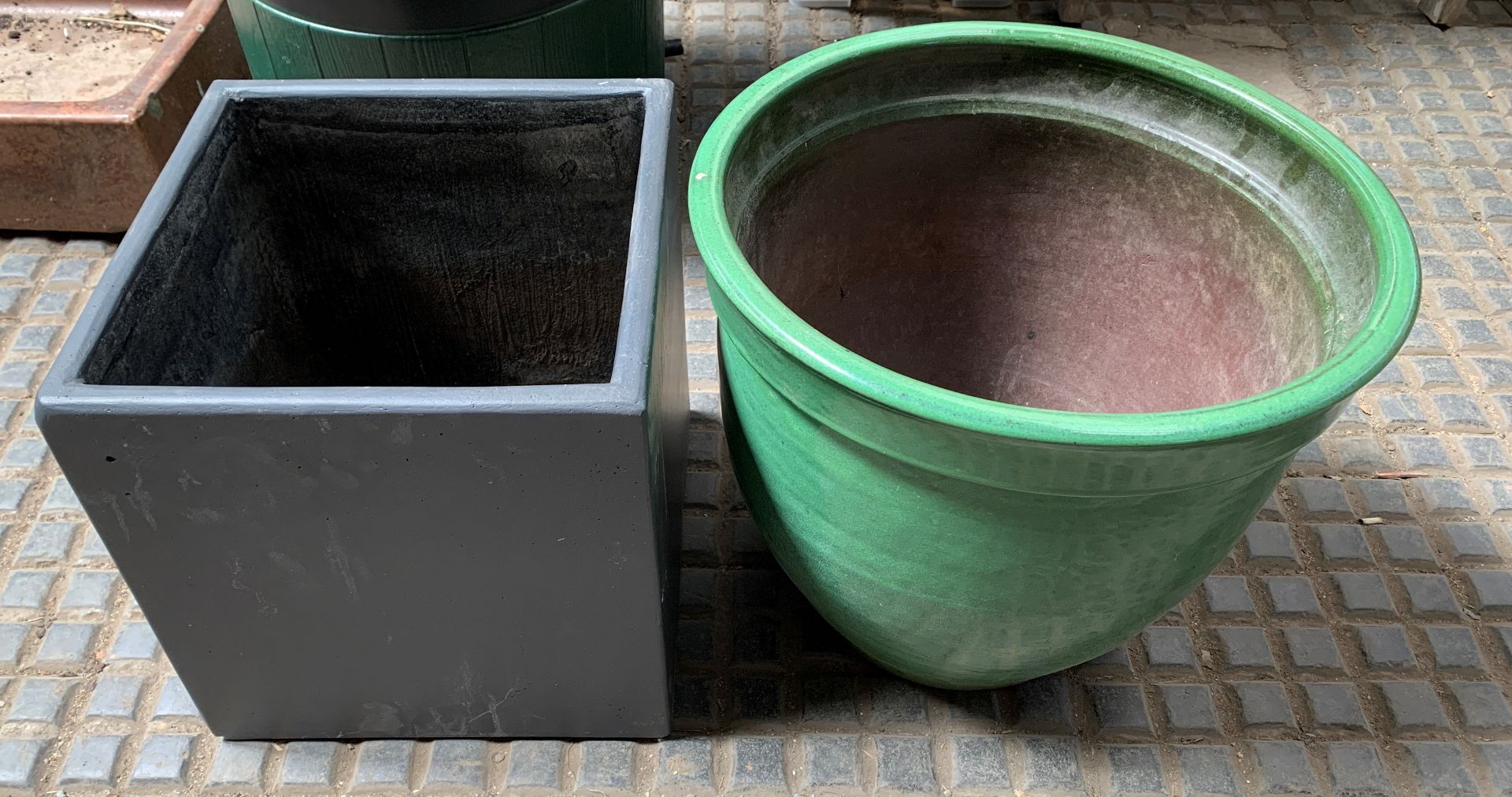 A green ceramic planter and another planter