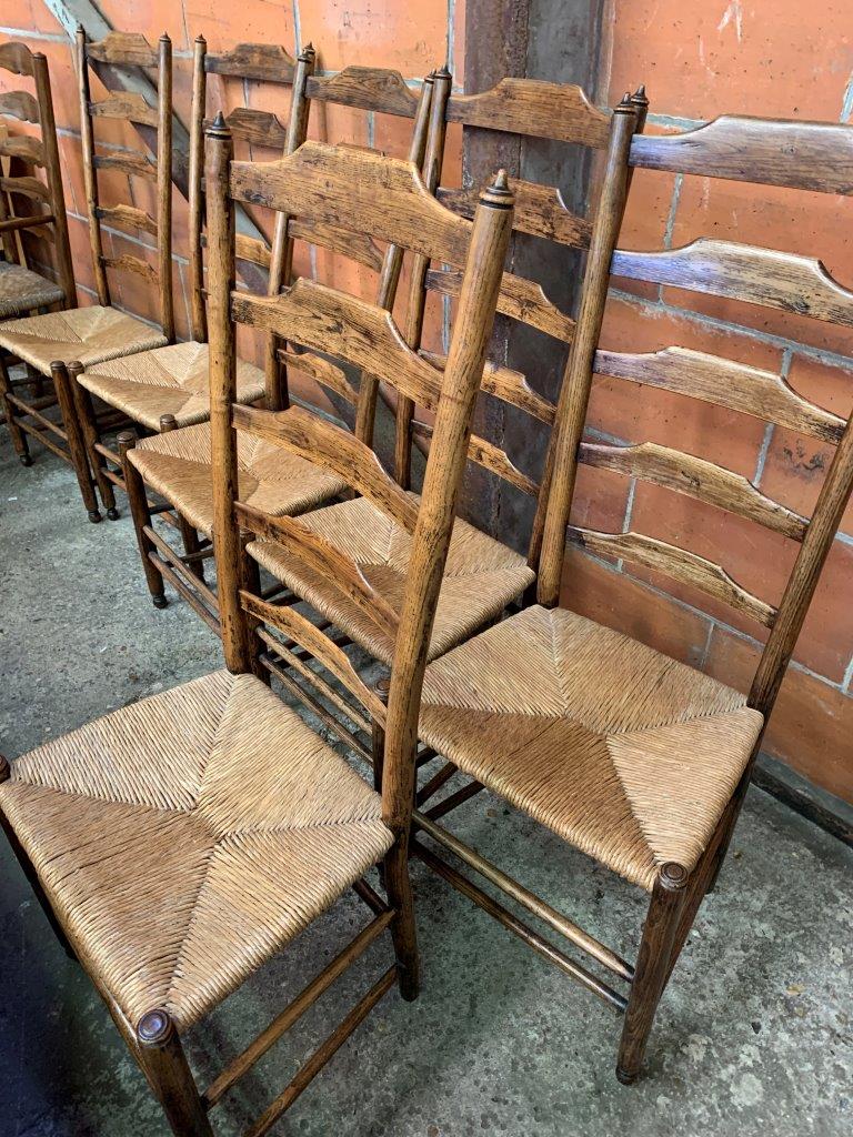 Six oak framed high ladder back chairs with string seats