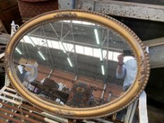 An oval gilt framed wall mirror