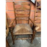 Oak framed ladder back open arm chair with string seat