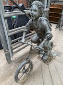 Metal sculpture of a school boy on a bike