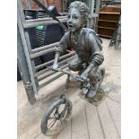Metal sculpture of a school boy on a bike